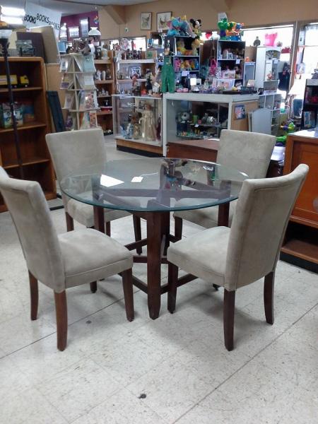 This glass table with grey suede, high back chairs would make a great addition to any dinning room! 